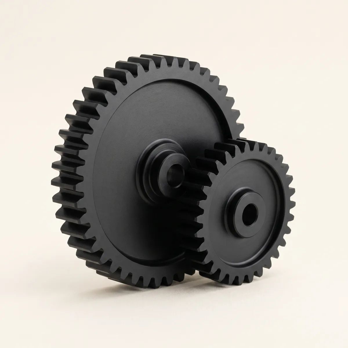 Two meshed matte-black gears at rest — a mechanism that turns without a hand on it.