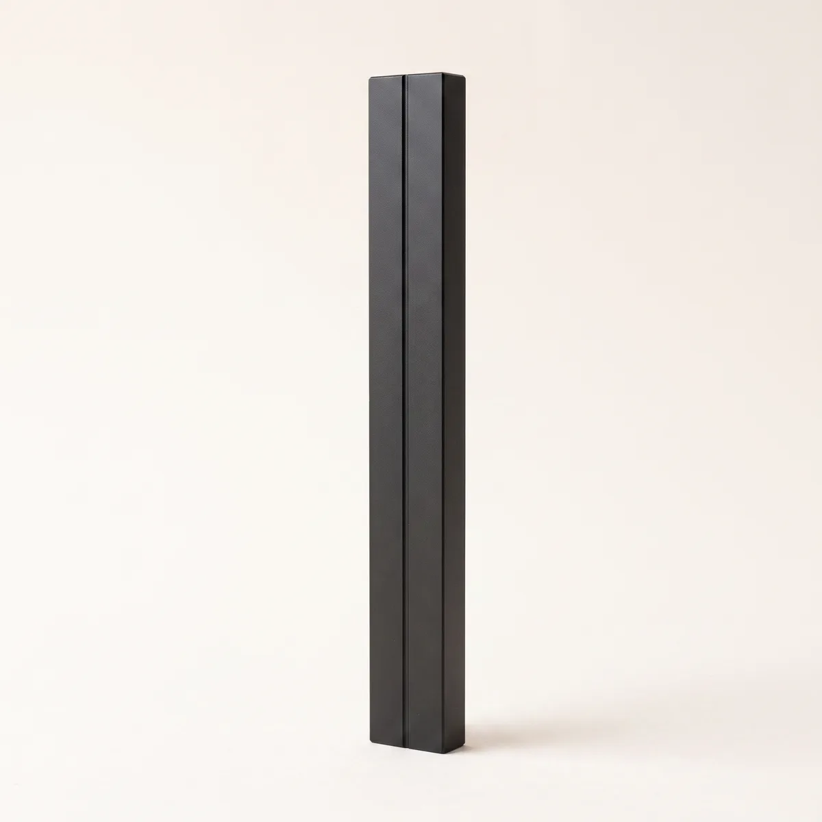 A single upright matte-black bar with one engraved line — one number to decide on.