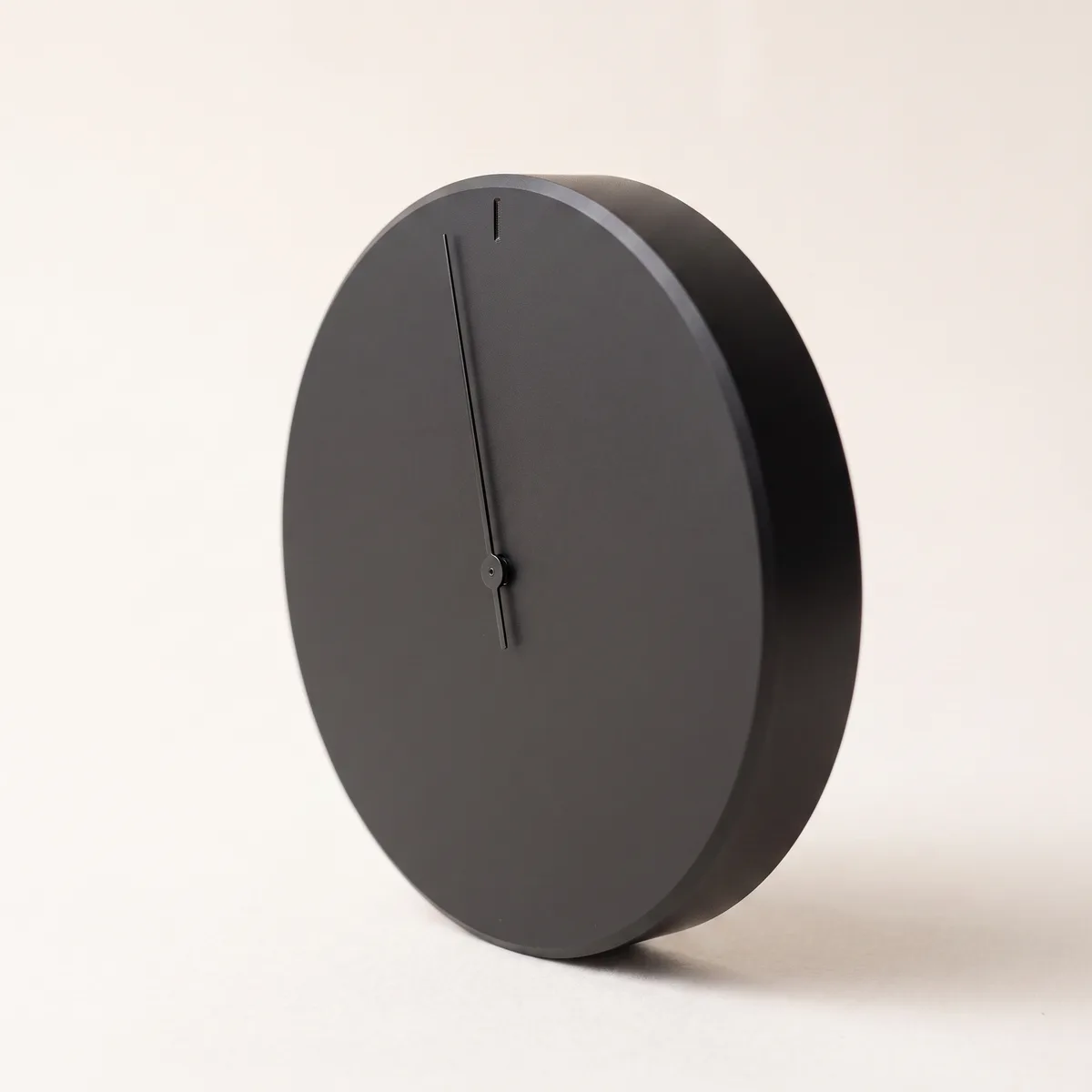 A matte-black precision dial with one hairline needle — an instrument reading the right signal.